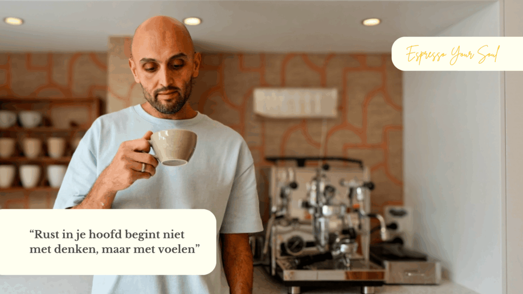 Een man staat in een lichte keuken met een kop koffie in zijn hand. Hij kijkt rustig naar het kopje terwijl hij nadenkt. Achter hem staat een espressomachine. Op de afbeelding staat de tekst: “Rust in je hoofd begint niet met denken, maar met voelen.