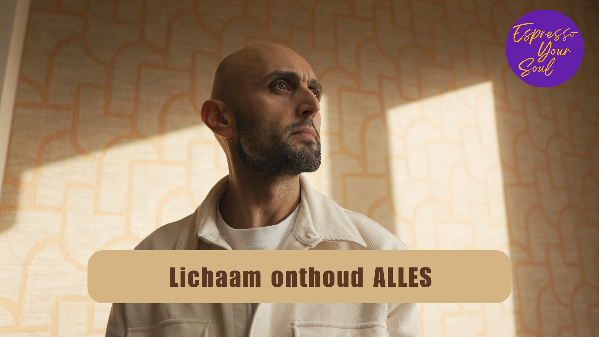 Dogac Akdag staat in een rustige, warme setting terwijl zacht licht door het raam valt. De thumbnail bevat de titel ‘Wat bedoelen we met je lichaam onthoudt alles?’ en straalt reflectie, aanwezigheid en innerlijke rust uit.